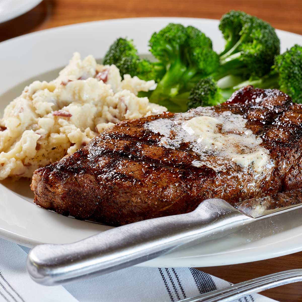 New York strip steak with mashed potatoes and broccoli at Burtons Boca Raton location